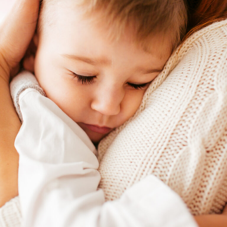 kind schuilt bij een ouder