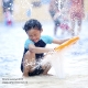 kind speelt met water aan zee