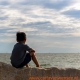 jongetje kijkt uit over zee