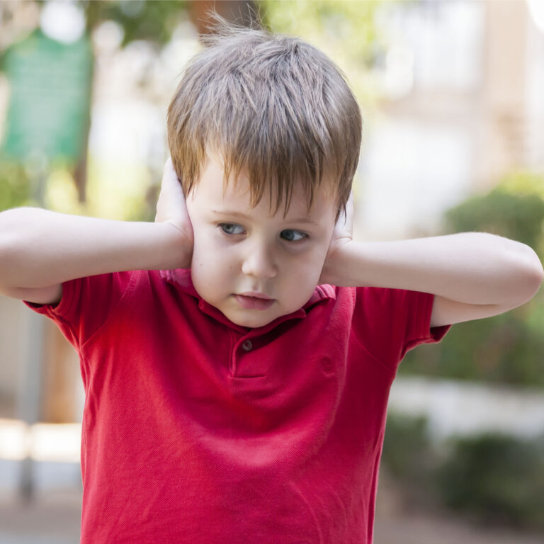 overgevoelig voor geluid kind en houdt zijn handen voor zijn oren