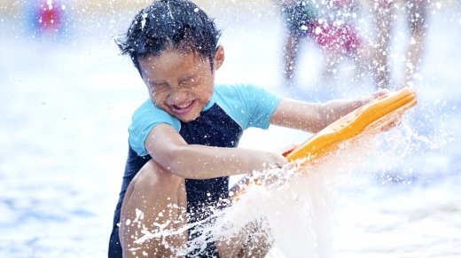 kind speelt met water aan zee